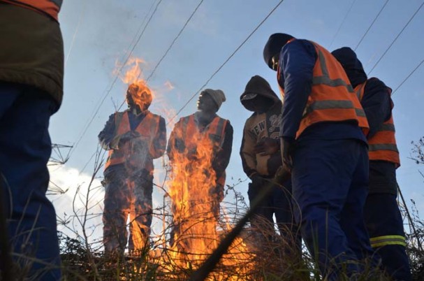 Construction workers stand around a fire to keep warm, 06 June 2014, in Industria West, Johannesburg. Residents of Johannesburg are expecting temperatures to drop as a cold front passes through the country. Picture: Alaister Russell