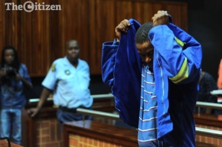 Truck driver Isaac Maruding attempts to cover his head during a court adjournment of his bail application at the Palm Ridge Magistrate's court, 22 October 2014. Maruding is appearing on charges of culpable homicide. Picture: Refilwe Modise